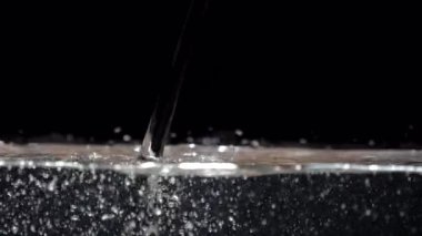 Akvaryumda yavaş hareket eden su akımı siyah bir arkaplanda düşer.