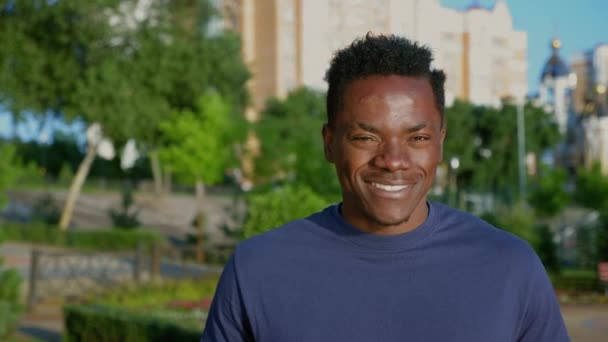 Κοντινό πλάνο χαμογελαστός πατριώτης Αφρο-Αμερικανός άνδρας που κρατά αμερικανική σημαία κοιτάζει κάμερα — Αρχείο Βίντεο