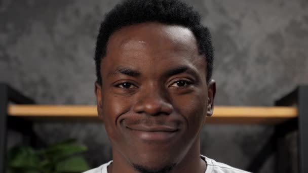 Γκρο πλαν χαμογελαστό πρόσωπο Αφροαμερικανός άνδρας ψάχνει κάμερα, στέκεται στο γραφείο — Αρχείο Βίντεο