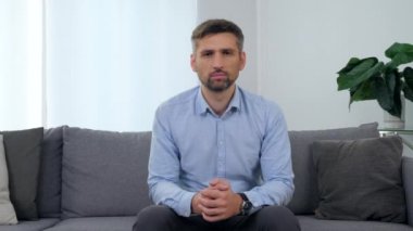 Klinikteki koltukta oturan yetişkin bir hastanın portresi.