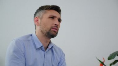 Akıl sağlığı yerinde olan yetişkin bir adam klinikte doktor psikologla konuşuyor.