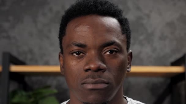 Närbild allvarliga ansikte afroamerikanska mannen tittar kamera, stående i ämbetet — Stockvideo