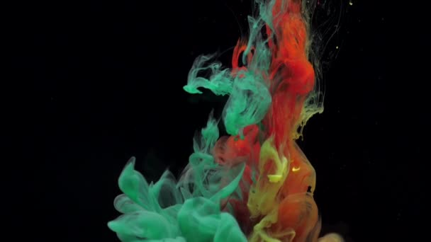 Zeitlupe grün-rote und gelbe Tinte mischen sich im Wasser und wirbeln sanft unter Wasser — Stockvideo