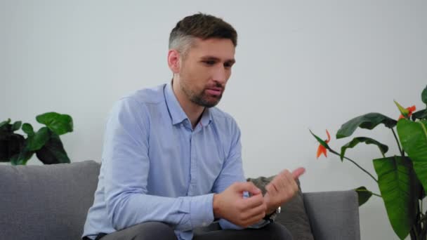 Homem adulto irritado com saúde mental conversando com o médico psicoterapeuta na clínica — Vídeo de Stock