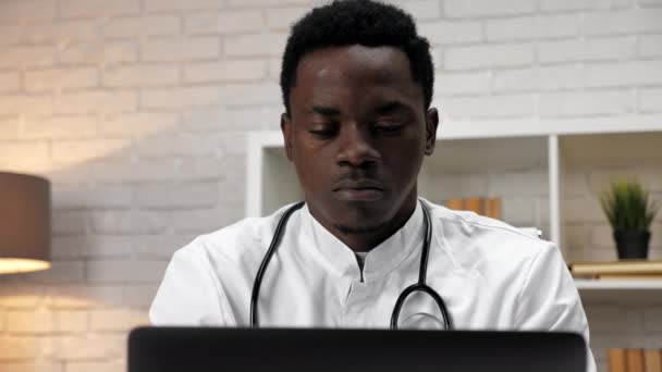 Primer plano afroamericano hombre médico trabajo utiliza computadora en clínica oficina — Vídeo de stock