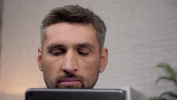 Close up faccia uomo trader broker guarda tablet tracce quotazioni in borsa — Video Stock