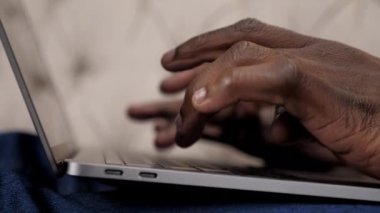 Evdeki klavye dizüstü bilgisayarında yazı yazan Afrikalı Amerikalıyı kapat