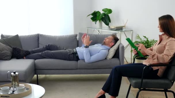 Mujer psicóloga sentada en silla escucha paciente en sesión de psicoterapia — Vídeos de Stock