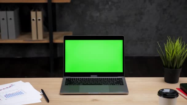 Ordinateur portable avec écran vert debout sur la table de travail bureau lieu de travail — Video