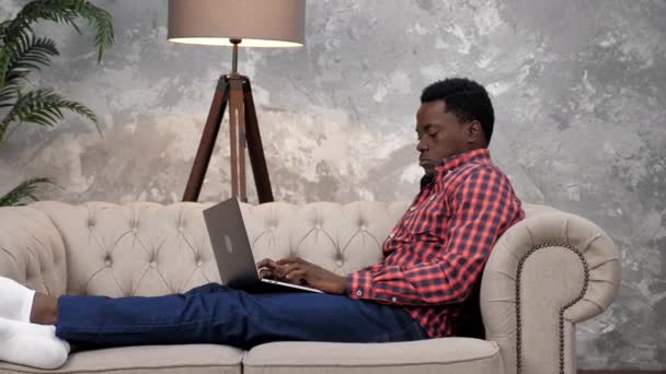 Empresario afroamericano trabaja portátil en línea charlando con los empleados de la empresa — Vídeo de stock