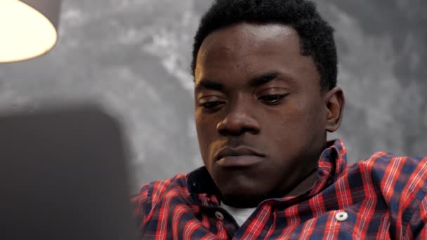 Empresario afroamericano trabaja portátil en línea charlando con los empleados de la empresa — Vídeo de stock