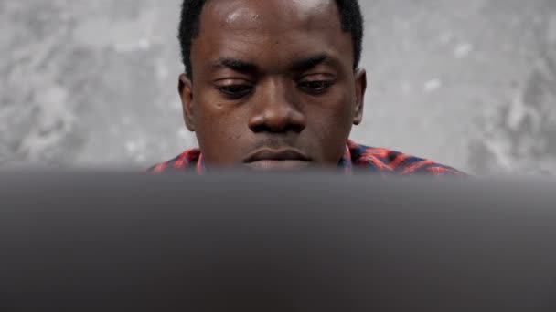 Крупным планом афроамериканский бизнесмен работает ноутбук болтая с сотрудниками — стоковое видео