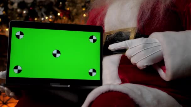 Close up modern Santa Claus points finger at laptop with green screen markers — Stock Video