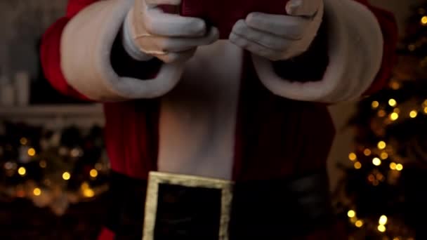 Närbild hand jultomten ger gåva i festlig röd låda, jul semester — Stockvideo