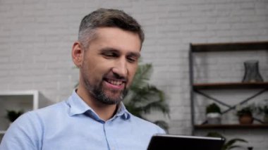 Gülümseyen adam komisyoncusu borsada tablet analizleri kullanıyor.