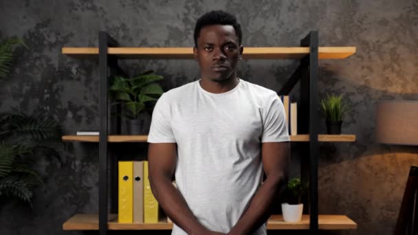 Afroamerikaner steht im Büro vor dem Hintergrund von Büroinventar. — Stockvideo