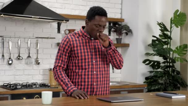 Stanco afroamericano studente uomo in piedi al tavolo della cucina e sbadiglia — Video Stock