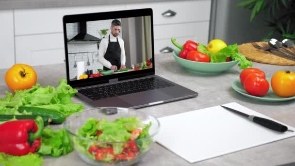 Computador portátil com homem chef comida blogger fatias pepino diz ensina estudante — Vídeo de Stock