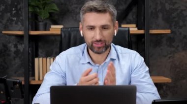 Gülümseyen Adam borsacısı online laptop web kameralı konferans görüşmesi yapıyor.