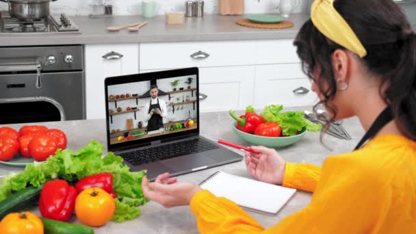 ホームキッチン研究の女性オンラインビデオ通話ウェブカメラのラップトップリッスンシェフ先生 — ストック動画