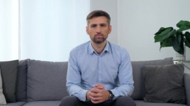 Klinikteki koltukta oturan yetişkin bir hastanın portresi.