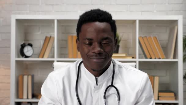 Homme afro-américain souriant médecin en manteau médical regardant caméra à l'hôpital — Video