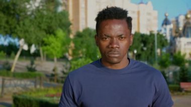 Amerikan bayrağı taşıyan ciddi vatansever Afro-Amerikan adam kameraya bakıyor.