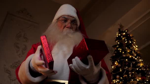 Santa Claus sonriente abre la caja de regalo roja y se sorprende, vacaciones de Navidad — Vídeo de stock