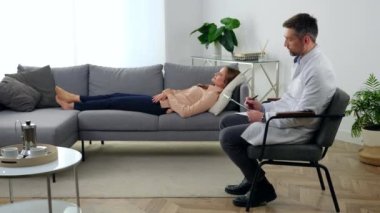 Klinikteki hasta dosyalarıyla konuşan psikoterapist adam.