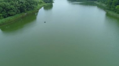 Hava manzaralı balıkçı gölde şişme bir teknede balık tutuyor.