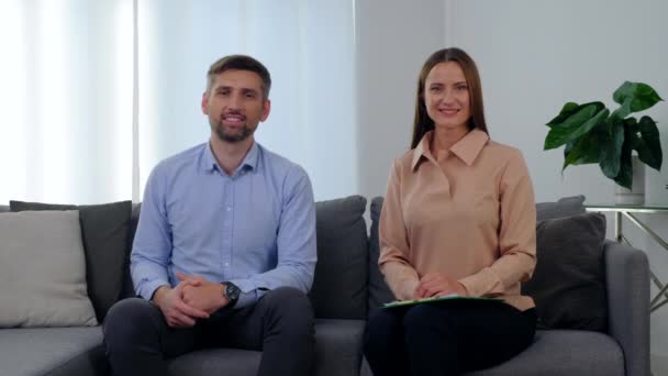 Retrato sonriente mujer psicólogo y feliz hombre paciente sentado en el sofá — Vídeo de stock