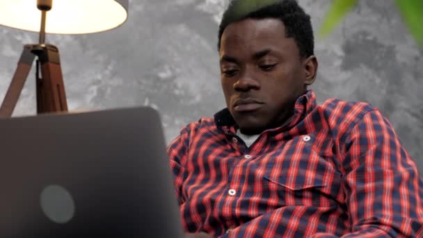 Hombre afroamericano adulto freelancer trabaja para computadora portátil escribiendo texto en el teclado — Vídeo de stock