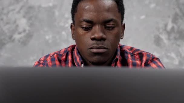 Lähikuva kasvot Afrikkalainen amerikkalainen liikemies työskentelee kannettava tietokone chattailuun työntekijöiden kanssa — kuvapankkivideo