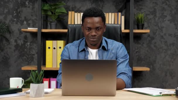 Usmívající se africký podnikatel naslouchá online zaměstnancům notebook webcam — Stock video