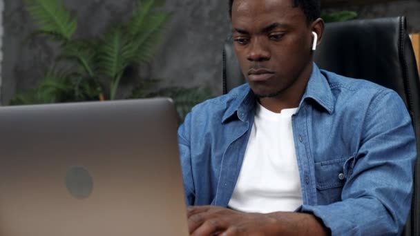 Афроамериканец работает в онлайновом чате с сотрудниками компании — стоковое видео