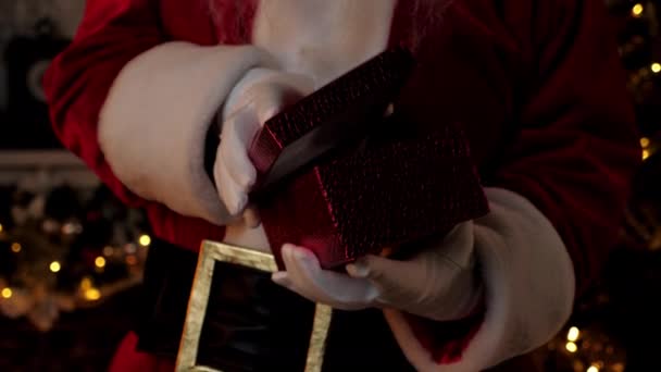 Închide mâinile Moș Crăciun deschide cutie de cadouri roșii, sărbătorile de iarnă de Crăciun — Videoclip de stoc