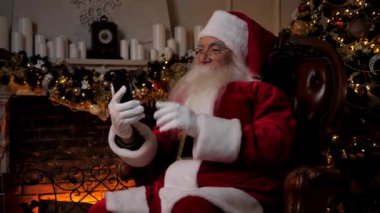 Modern gülümseyen Noel Baba çocuklara online akıllı telefon görüşmeleri yapıyor.