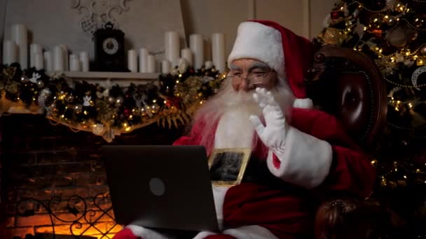 Moderní usmívající se Santa Claus pozdravuje rozhovory s dětmi on-line notebook video hovor — Stock video