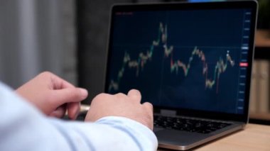 Adam borsa simsarı bilgisayarını borsa ekran grafiği ile kullanıyor.