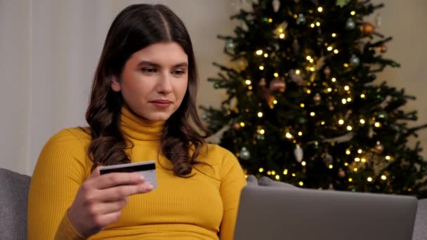 Kvinnan anger kreditkortskod för att betala nyårspresenter online shopping via laptop — Stockvideo