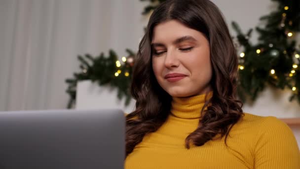 Close-up glimlachen jonge vrouw maakt gebruik van laptop online chatten, kerstvakantie — Stockvideo