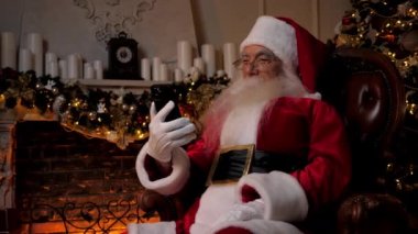 Modern gülen Noel Baba akıllı telefondan komik şovlar izliyor, Noel 'de.