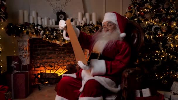 Carta de lectura de Papá Noel con los regalos de la lista de los niños para las vacaciones de Navidad — Vídeo de stock