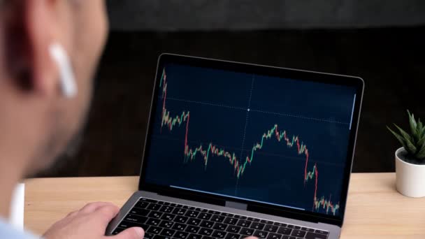 Homem cabeça corretor de ações usa laptop com tela de gráfico bolsa de valores — Vídeo de Stock