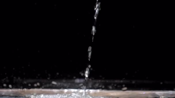 Flux d'eau à mouvement lent descend dans l'aquarium sur un fond noir — Video