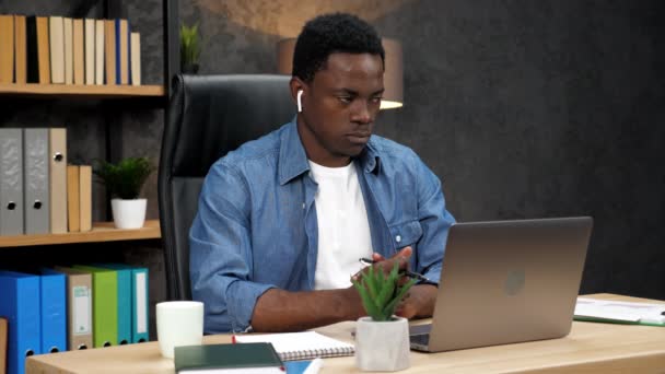 Афро-американский бизнесмен слушает видео-переговоры сотрудников в интернете — стоковое видео