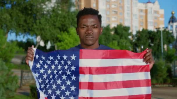 Portrait Afro-American man holding American flag looks camera said USA in summer — Stok Video