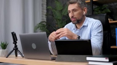 Gülümseyen iş adamı şirket çalışanlarıyla internet üzerinden webcam görüntülü konuşma yapıyor