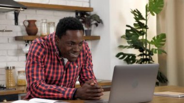 Heyecanlı Afrikalı Amerikalı erkek kazanan dizüstü bilgisayara bakıyor online başarıyı kutluyor