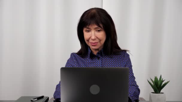 Lachende zakenvrouw werkt voor laptop online chatten, maakt gebruik van computer op kantoor — Stockvideo